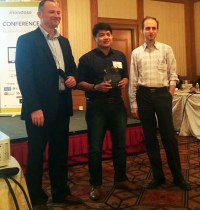 USAID's Steve Rynecki (left) presents the "Social Impact of the Year Award" to Rob Nazal of BPI Globe BanKO (center) in a ceremo