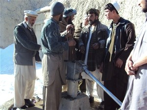 A newly trained mechanic is fixing a nonfunctioning hand-pump with community support in Paktia Province.