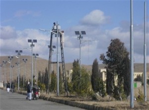 Technicians install LED lamps and solar panels for streetlights at Shaikh Zahed University.