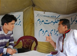 An editor with the program (left) completes an interview as part of the “Weekly Interview” segment of the website.
