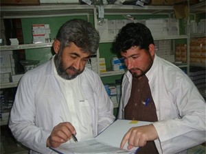 Dr. Sayed Afandi, Medical Director of the Jalalabad Public Health Hospital, reviews pharmacy records with Pharmacist Ziaulhaq.