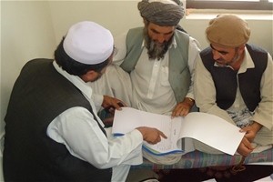 USAID field personnel distribute and demonstrate how to use the new decision letter booklets with village elders in Surkhrod Dis