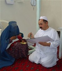 A community health worker treats a child with pneumonia, explaining the treatment to her mother.