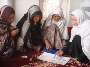 Female community health worker teaches Afghan mothers to improve hygiene in their homes through regular hand washing.