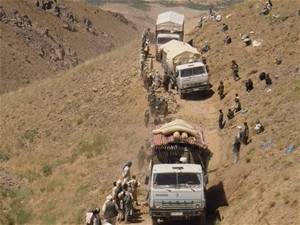 Pashtun and Hazara laborers clear a path as supply trucks crawl up the narrow Tamazan Road.