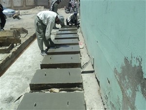 Concrete culvert covers cure under the sun after being fabricated by newly-trained laborers working on a municipal development p