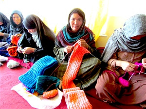 Khadeeja, one of the women who is receiving training on making quality cashmere clothing, knits a scarf.