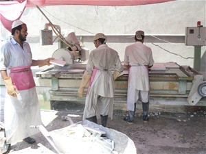 Laborers processing marble at the Sahil Tora Bora Marble Processing Facility, Surkh Road District, Nangarhar Province.