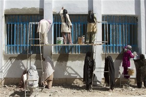 In Farah City, women work on the exterior of the Women’s Affair’s building. More than 410 female laborers were hired for major r