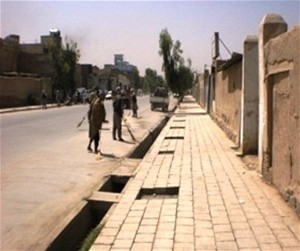 Workers put the final touches on a sidewalk in Kandahar. The city government initiated what became a very successful public work
