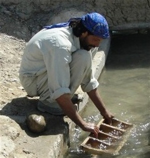 A laborer in Khar Lando Village cleans a karez leading to the canal.