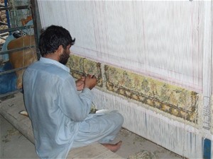 A weaver weaves carpet for ZRM Carpet Company