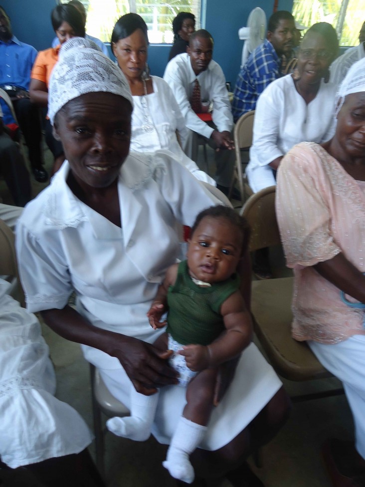 Tilma, a traditional birth attendant in rural Haiti, holds a healthy baby boy delivered by one of her patients. 