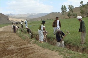 Ghor residents gravel a road and dig a drainage ditch to prevent flooding. Improved roads allow better access to markets, school