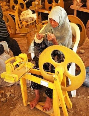 An Afghan woman uses a foot-treadle spinning wheel that has boosted her productivity and helped to provide jobs for other local 