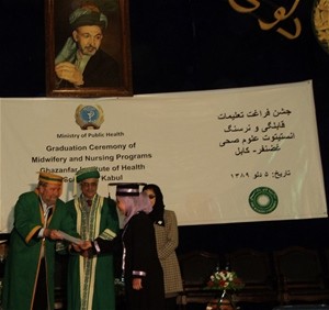 USAID Senior Deputy Mission Director Robert Hellyer hands the graduation certificate to a new mid-wife.