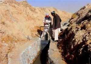 Members of the community in Shindand District in Herat Province watches as the karez is closed. This stops the water from flowin