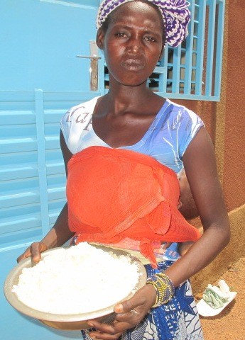 A mother holds a ration of Supercereal she received from USAID
