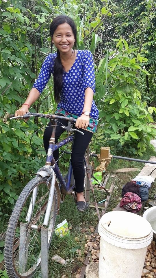 USAID trainee pumps water by riding a bike in Banke, Nepal.