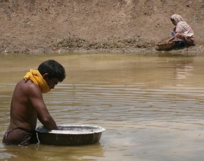 Photo of husband and wife building fish pond for fish farming