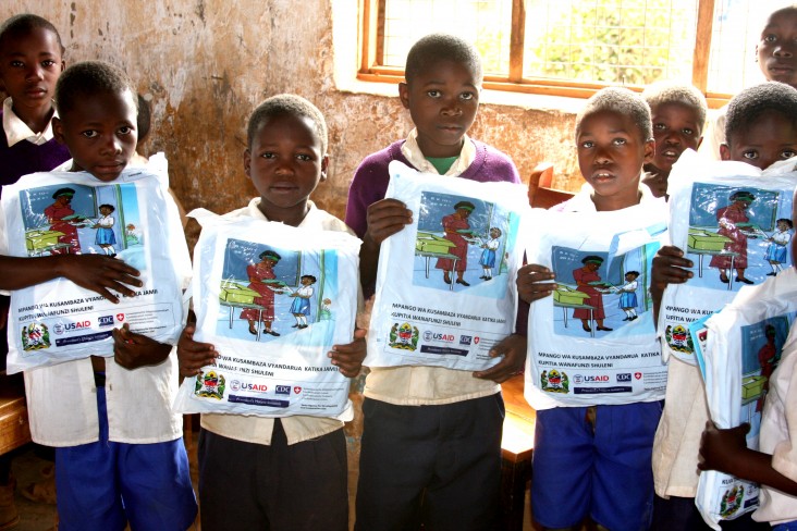 Students hold their new bed nets at Tanga Primary School.