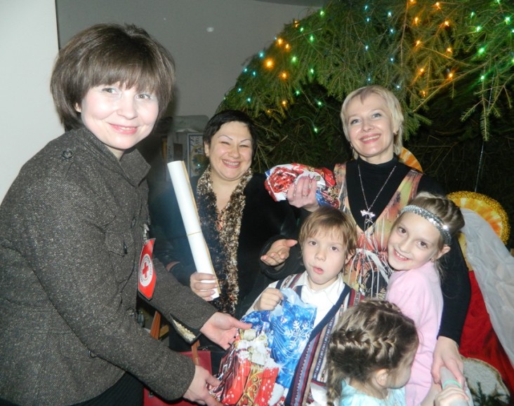 Татьяна  Пукало раздает  рождественские подарки детям с ограниченными возможностями на местном благотворительном мероприятии