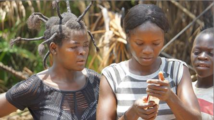 Two women use cell phones after obtaining service in DRC