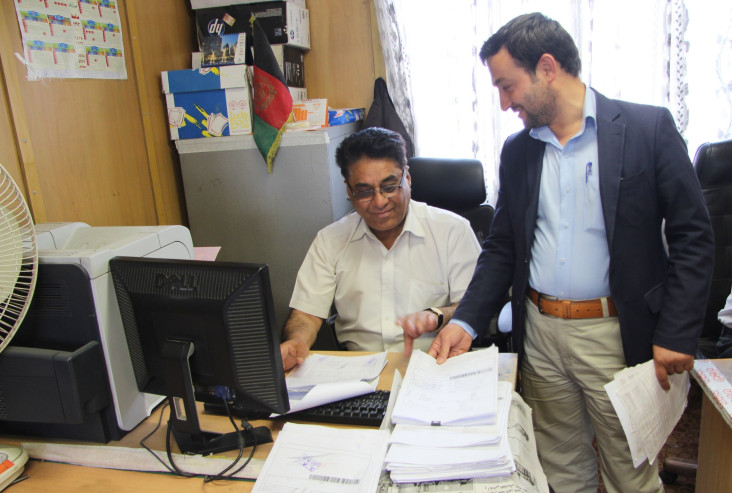 A telecommunications company employee checks with a customs official on release of his imports.