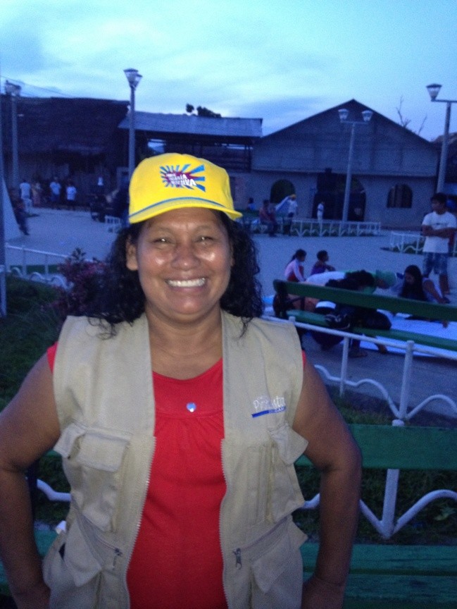 Maria Tereza Sangama wears a hat bearing the campaign slogan: Pure Collective Energy!