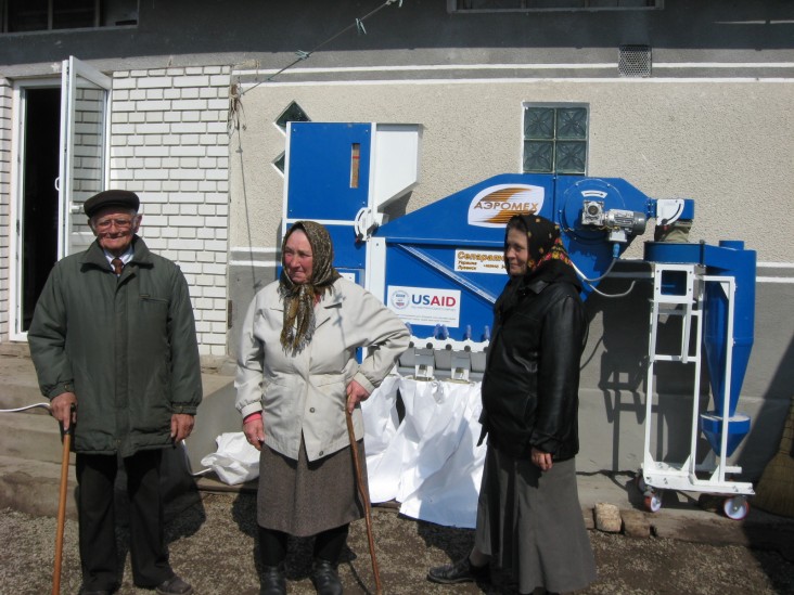 Three members of the Lypivsky cooperative with post-harvest processing equipment used to produce dried vegetables.
