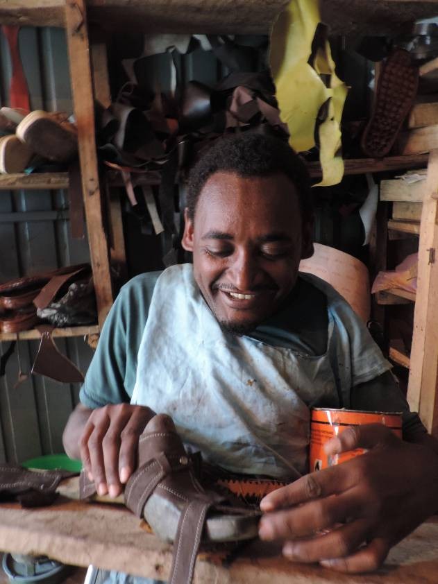 Melesse Yohannes uses his “Rough Rider” wheelchair to go out and buy supplies for his shoe-making and repair shop.