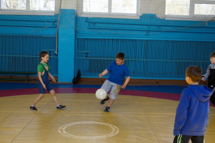 Школярі люблять грати у футбол в теплому спортзалі.