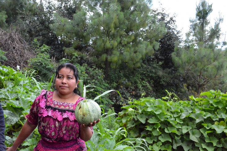 Sheny holds a vegetable from her home garden