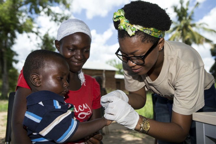 Neema Shosho, nutritionist, takes a blood sample from a child in Tanzania.