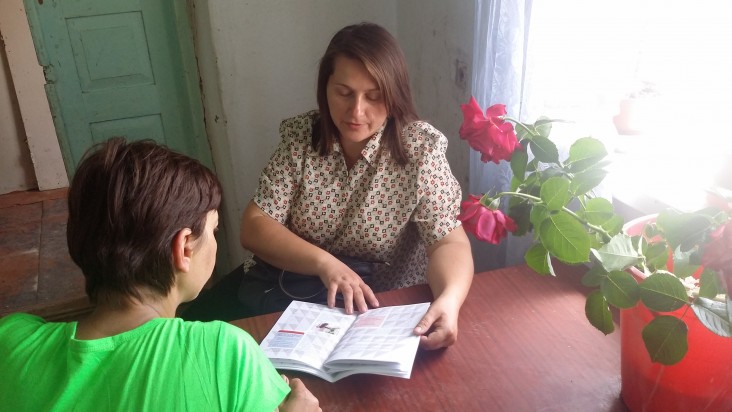 Nurse consulting a client using a “Patient’s Diary,” a booklet developed by USAID that tracks a patient’s treatment progress.