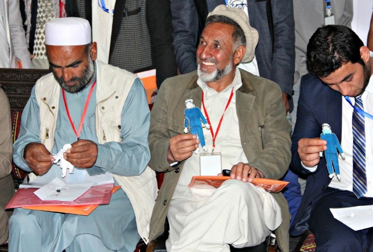 Participants of the USAID course put protective clothing on paper dolls 