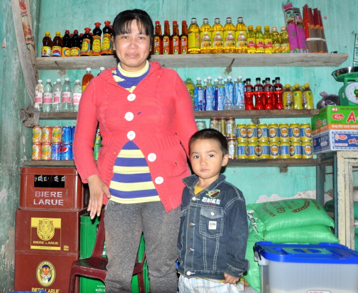 Pham Thi Gai and her son, next to the fully stocked shelves of her store. 
