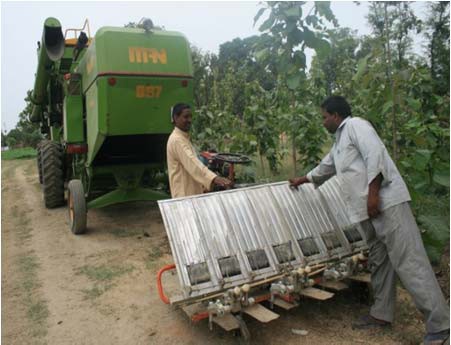 Ramavadh Chaudhary shows a farmer how to operate a mechanical rice transplanter.