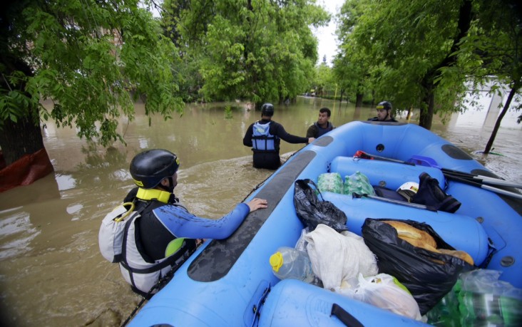 Rafters wade in waist-deep waters to rescue victims of flooding in Bosnia and Herzegovina.