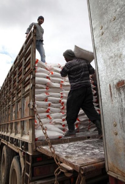 Workers load newly-milled flour onto a truck in Syria