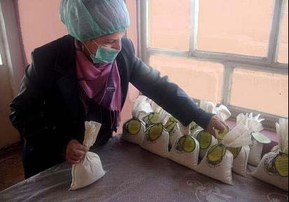 An Iraqi widow helps with packaging Anbar Rice as part of the Rawdi Widows and Orphans Welfare Organization’s job skills program