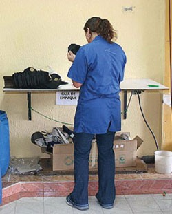 Tania, who now works for a clothing producer in Bogota, inspects baseball caps before they are packaged and sent to retail store