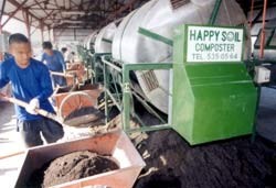 Workers from Luntiang Nasugbu Multipurpose Cooperative produce fertilizer at the CADP composting facility.