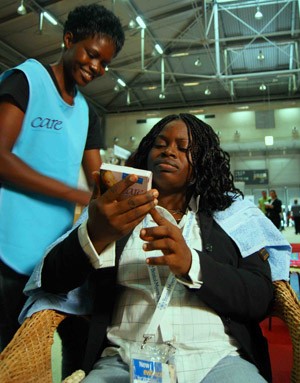 Tears Wenzira, left, speaks to a customer at the International AIDS Conference in Vienna in July 2010. 