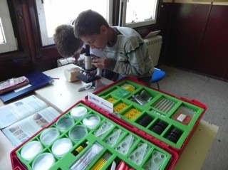 Student using newly USAID funded microscope