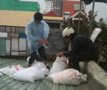 Staff prepare sandbags to reinforce the company's roof.