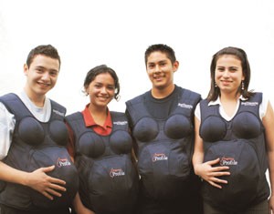 Young women and men in Guatemala try on “pregnancy suits” as part of reproductive health training for youth