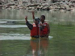 Staff from the Ministry of Natural Resources and Environment measure water levels on the Choluteca River.