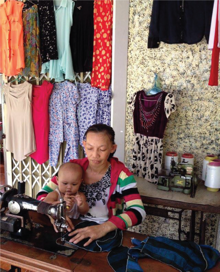 Pham Ngoc Yen repairs clothes in her shop.