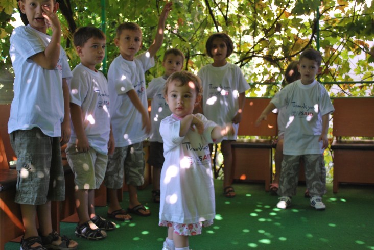 Children at the BAMBI daycare center playing in the garden during a USAID staff visit.